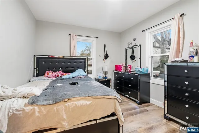 a bed sitting in a bedroom and dresser with a mirror