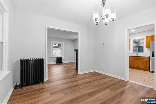 a view of a livingroom with wooden floor and kitchen space