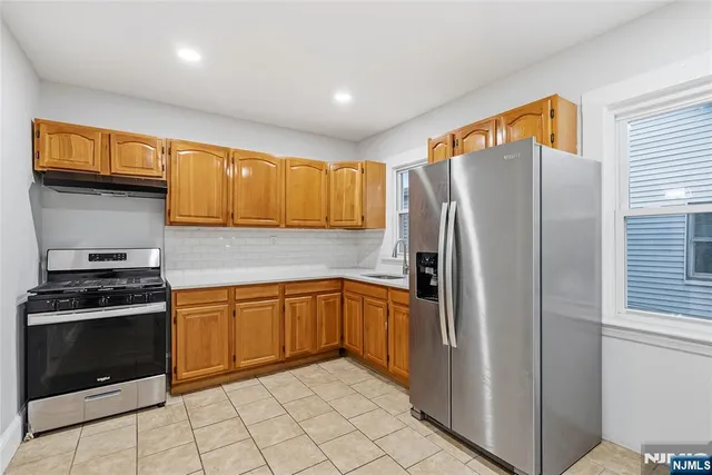 a kitchen with stainless steel appliances granite countertop a refrigerator and a stove top oven