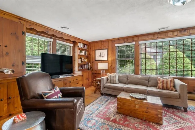 a living room with furniture a flat screen tv and a large window