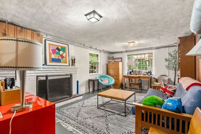 a living room with furniture a fireplace and a window