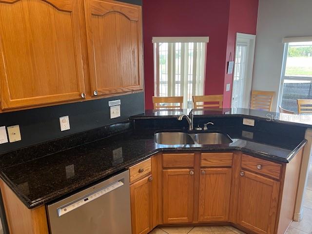 2533 Oneida Loop Kissimmee, FL 34747 - Photo 22 of 73 a kitchen with granite countertop cabinets and black appliances