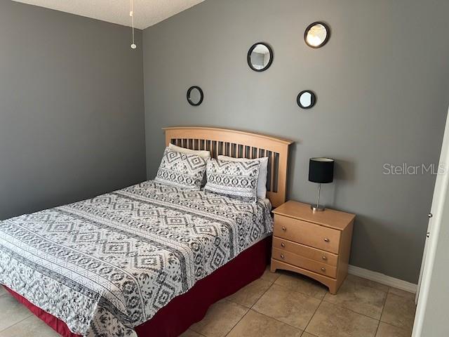 2533 Oneida Loop Kissimmee, FL 34747 - Photo 49 of 73 a bedroom with a bed and a lamp