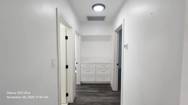 a view of a hallway with wooden floor