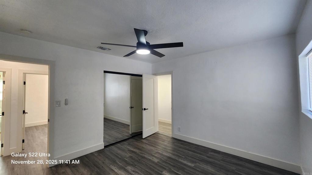 1303 Center Avenue Oceanside, CA 92054 - Photo 9 of 15 an empty room with wooden floor and a ceiling fan
