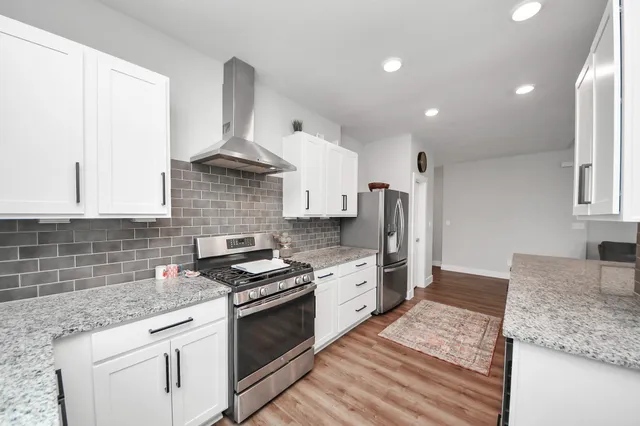 a kitchen with stainless steel appliances granite countertop a stove sink and cabinets