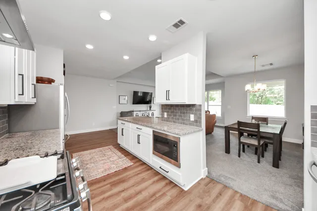a kitchen with stainless steel appliances kitchen island granite countertop a stove and a sink