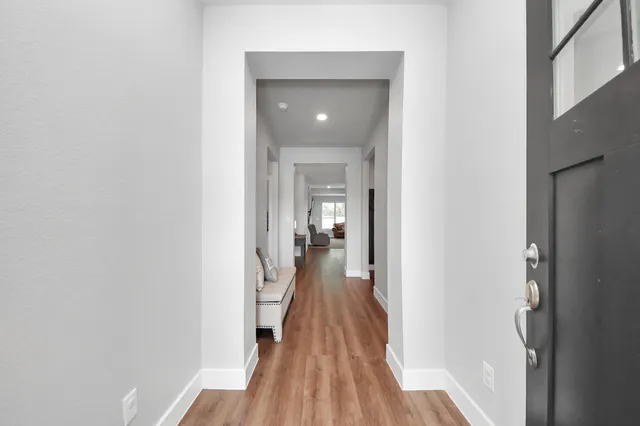 a view of a hallway with wooden floor and staircase