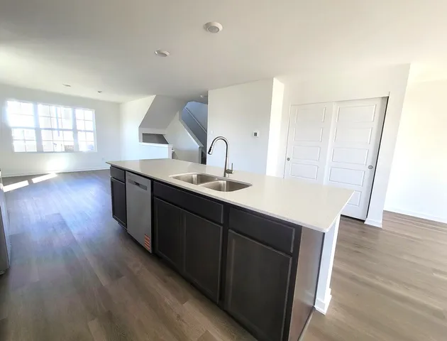 a kitchen with a sink and wooden floor