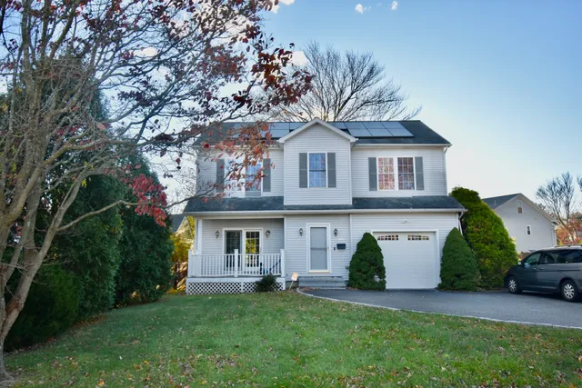 a front view of a house with a garden and plants