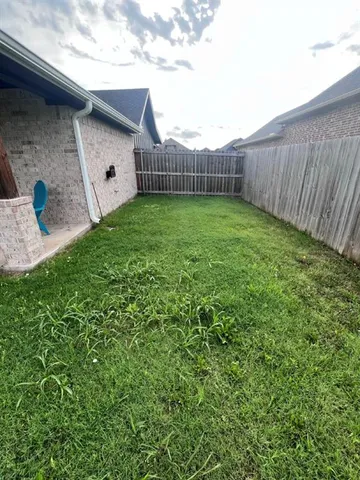 a view of a backyard with plants and wooden fence