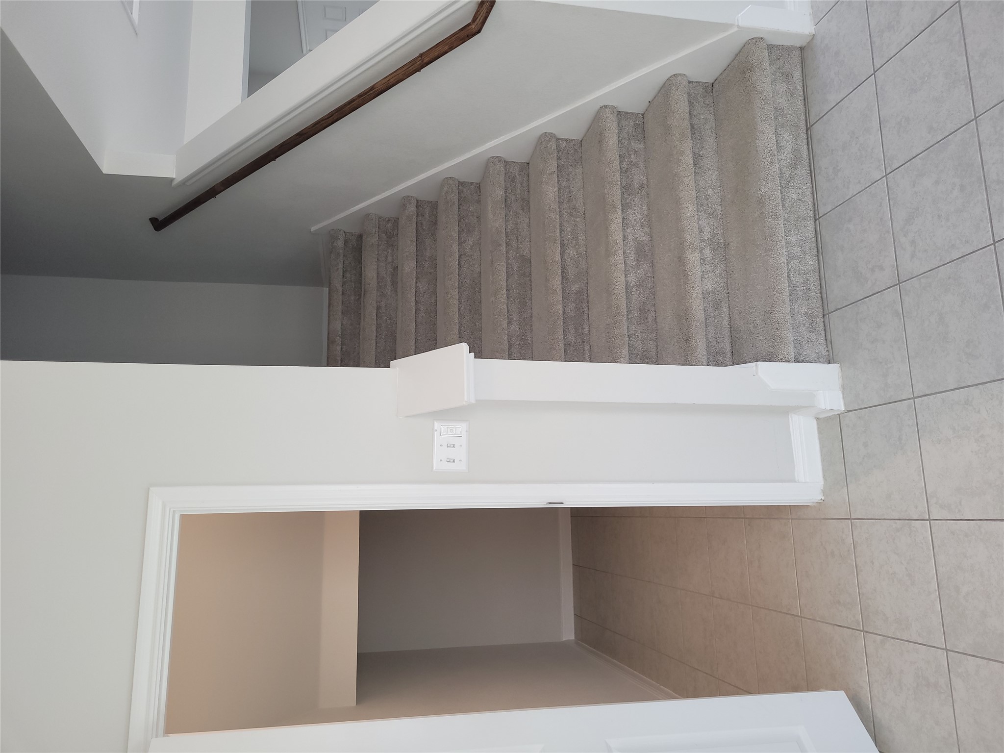 8308 Daisy Cutter Crossing Georgetown, TX 78626 - Photo 22 of 27 A well-maintained staircase with plush carpeting leads to upper levels, alongside a tiled entryway.