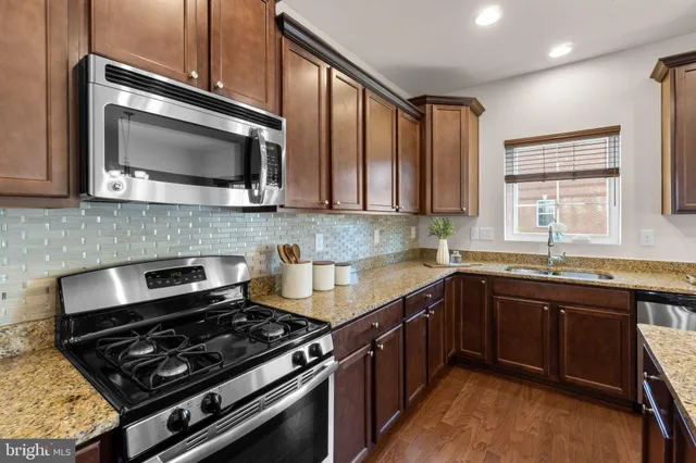 a kitchen with stainless steel appliances granite countertop a stove microwave and sink
