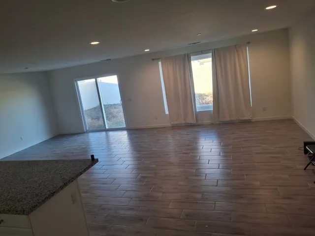 a view of a hallway with wooden floor and closet