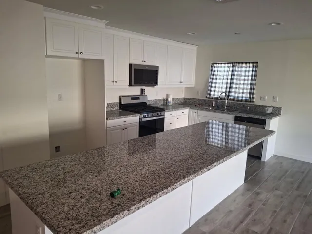 a kitchen with stainless steel appliances granite countertop a sink stove and refrigerator
