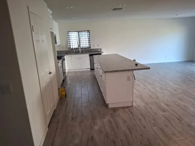 an empty room with wooden floor and stairs