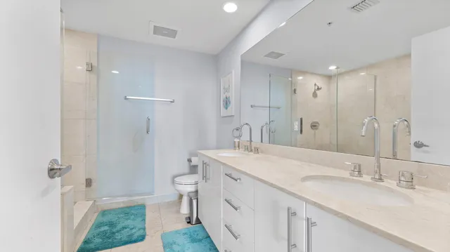 a bathroom with a double vanity sink toilet and a mirror