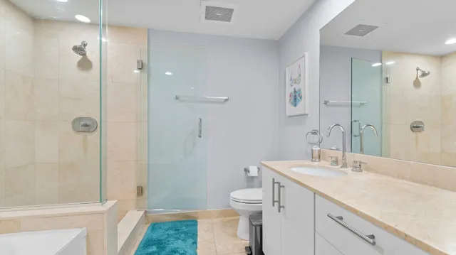 a bathroom with a sink a toilet and shower