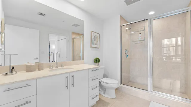 a spacious bathroom with a shower sink mirror and toilet