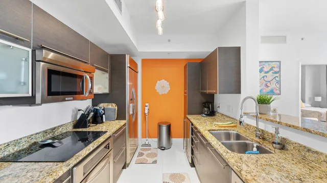a kitchen with stainless steel appliances granite countertop a sink stove and refrigerator