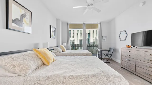 a bedroom with a large bed and a flat tv screen on dresser