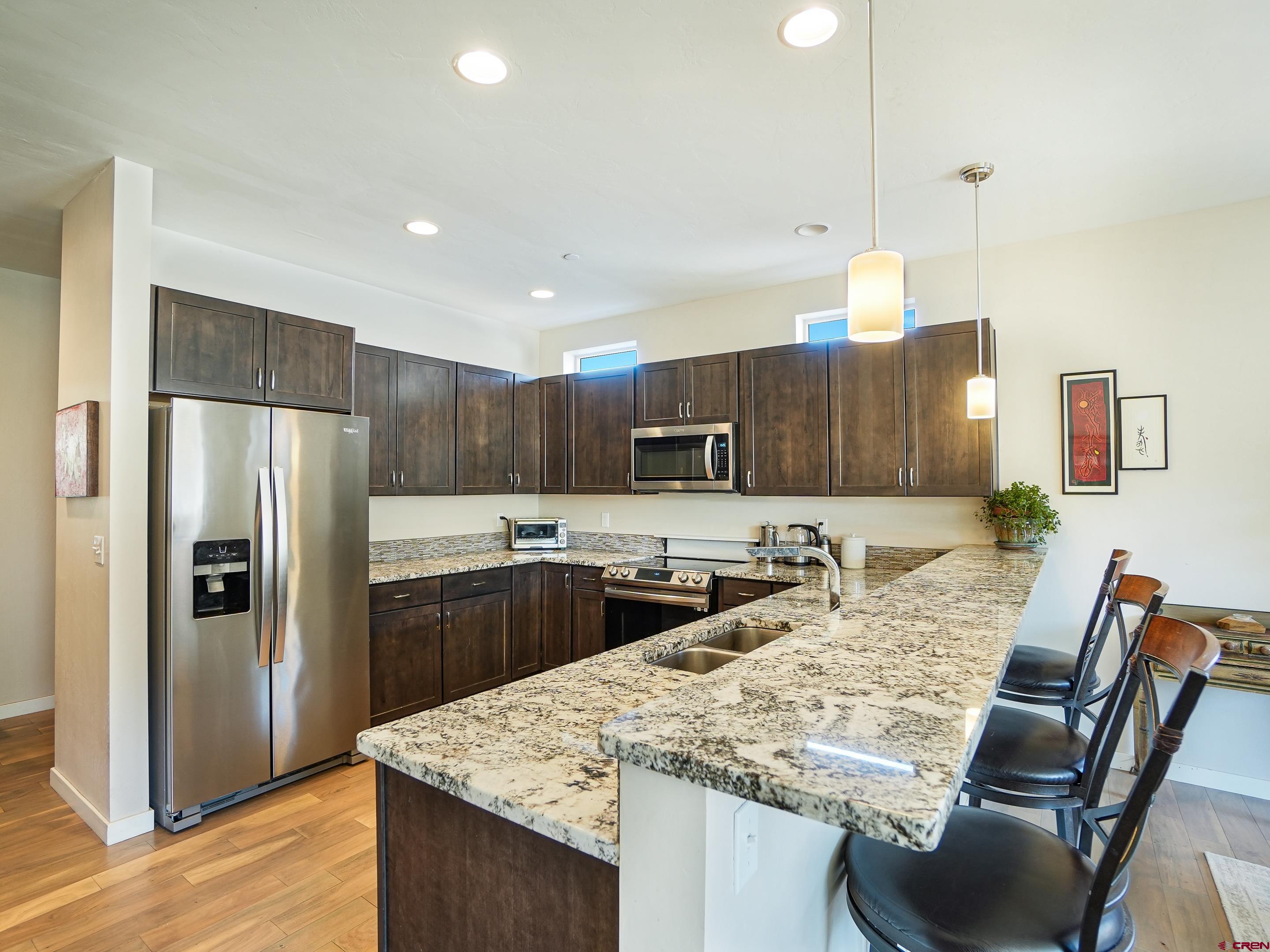 1422 Animas View Drive, Unit 18 Durango, CO 81301 - Photo 2 of 16 a kitchen with kitchen island a refrigerator stove and microwave