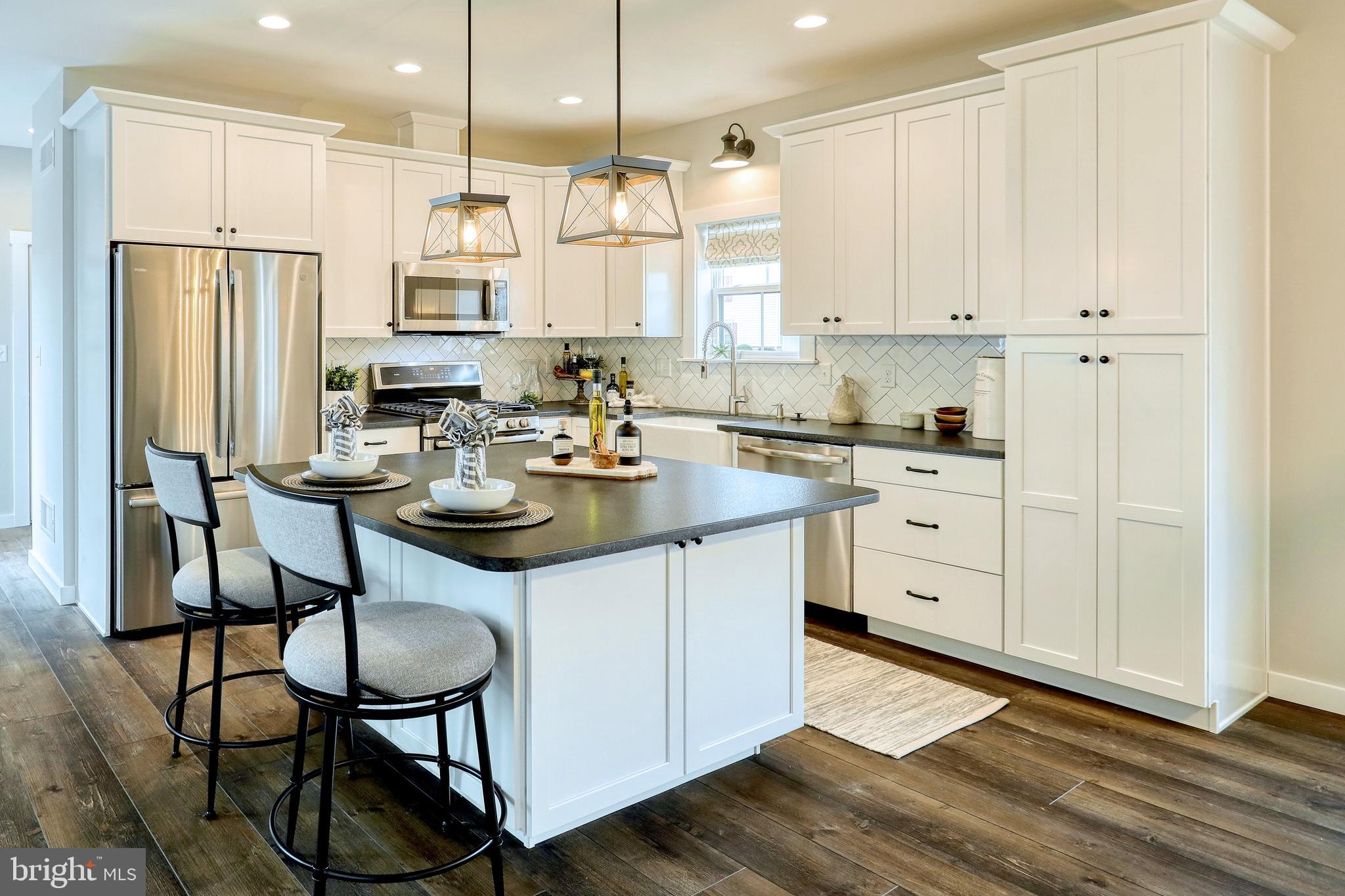 3145 East Joppa Road, Unit MILTON Parkville, MD 21234 - Photo 6 of 13 a kitchen with stainless steel appliances sink refrigerator dining table and chairs