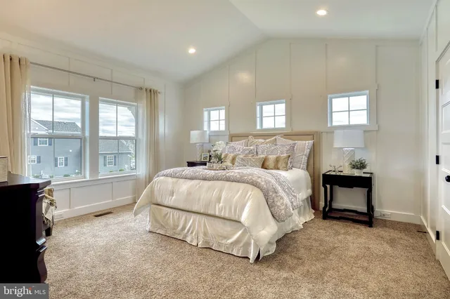 a spacious bedroom with a bed and a large window