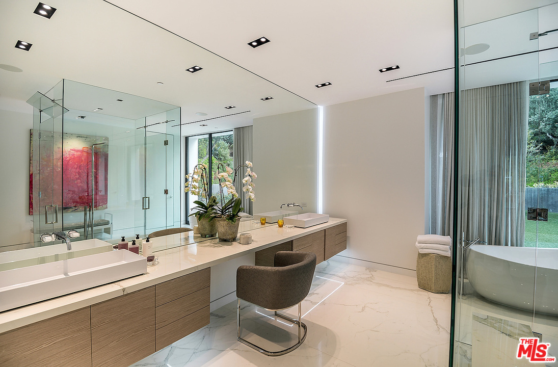 1012 North Hillcrest Road Beverly Hills, CA 90210 - Photo 35 of 54 a bathroom with a tub a sink and mirror
