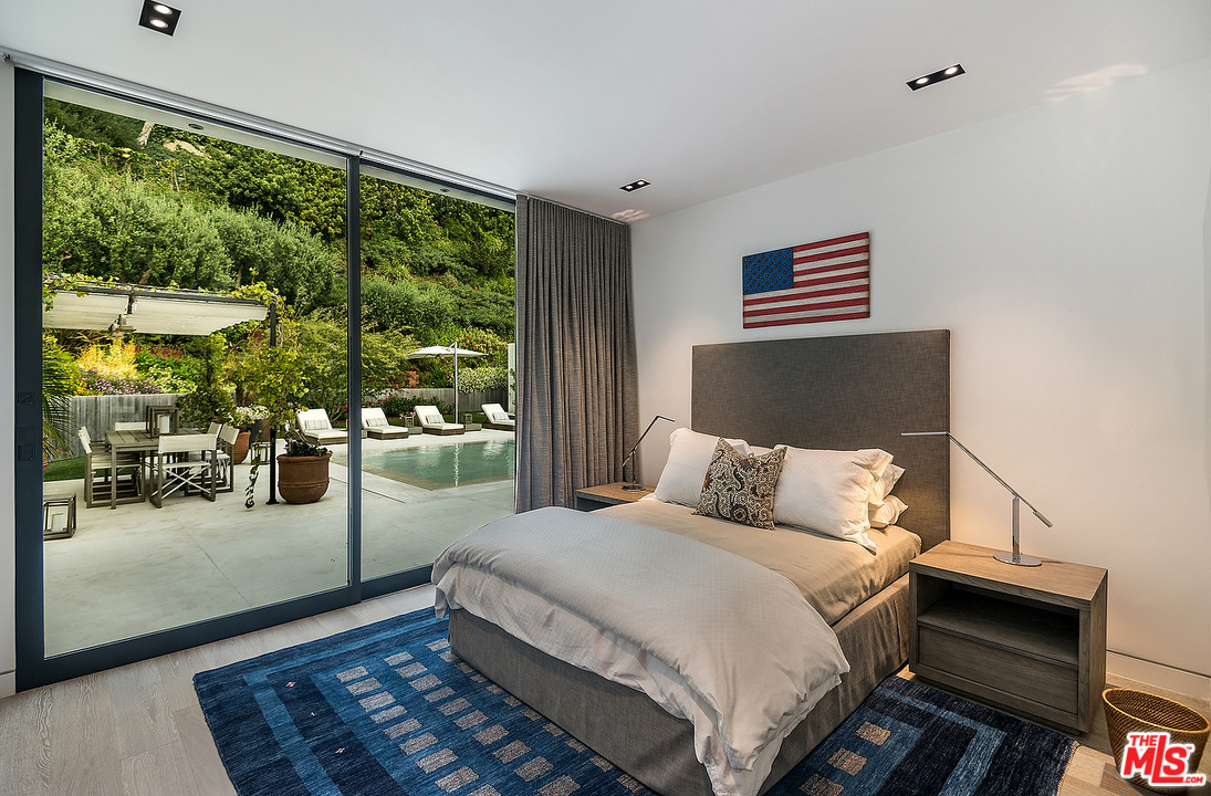 1012 North Hillcrest Road Beverly Hills, CA 90210 - Photo 41 of 54 a bedroom with a bed wooden floor and window