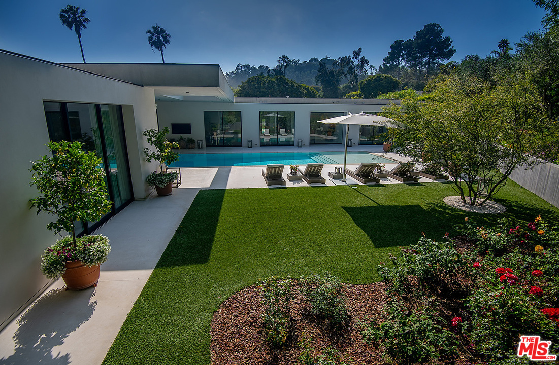1012 North Hillcrest Road Beverly Hills, CA 90210 - Photo 49 of 54 a view of a house with backyard sitting area and swimming pool