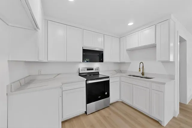 a kitchen with stainless steel appliances granite countertop a sink and a stove top oven