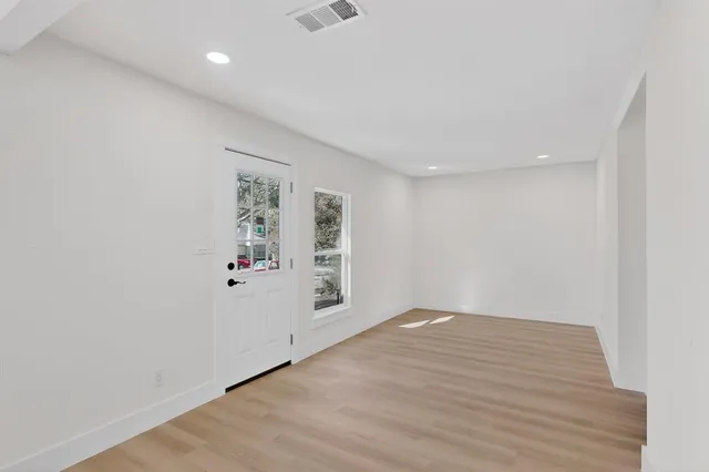 a view of empty room with wooden floor