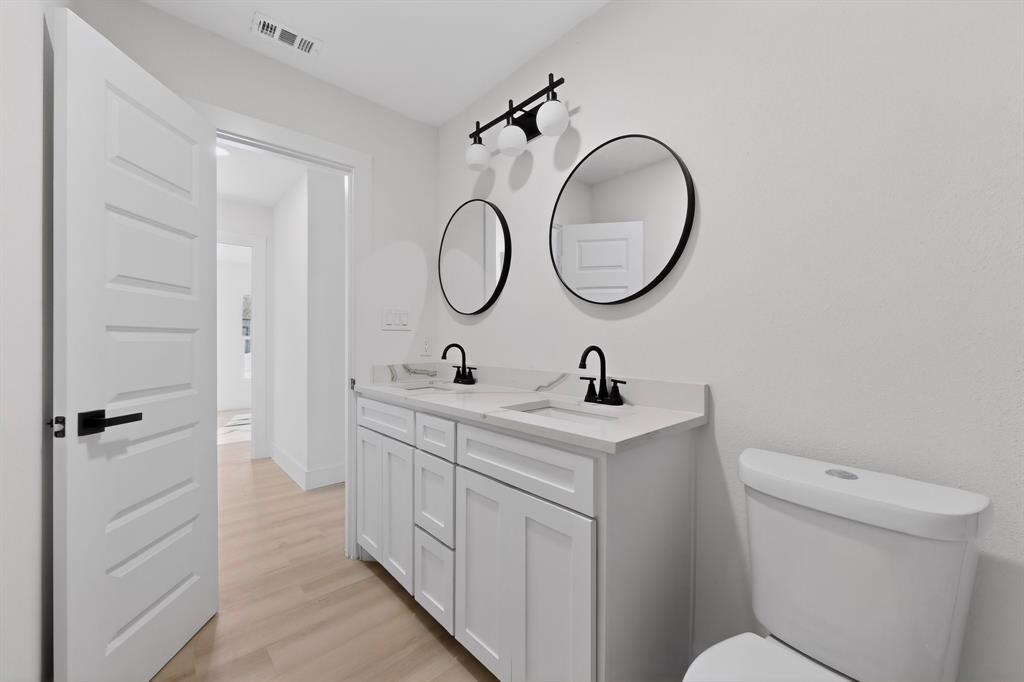 2219 Wilbur Street Dallas, TX 75224 - Photo 23 of 37 a bathroom with a toilet sink and mirror