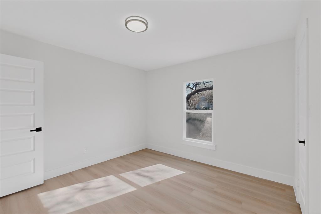 2219 Wilbur Street Dallas, TX 75224 - Photo 4 of 37 a view of an empty room with a window and wooden floor