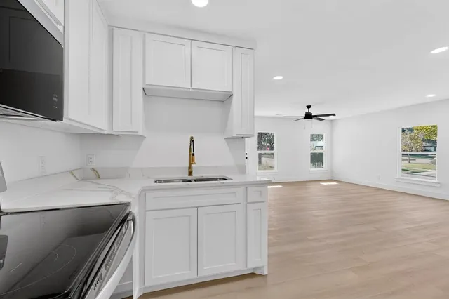 a kitchen with white cabinets and stainless steel appliances