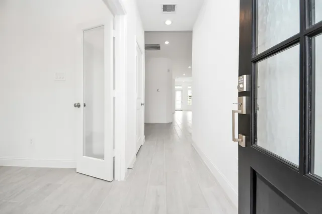 a large kitchen with stainless steel appliances kitchen island granite countertop a large counter top a sink dishwasher a stove and a refrigerator with wooden floor