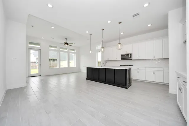a kitchen with kitchen island white cabinets and stainless steel appliances
