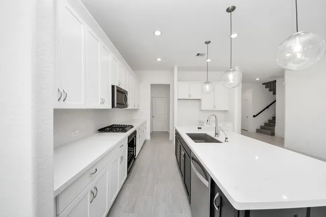 a view of a kitchen with a sink and stainless steel appliances