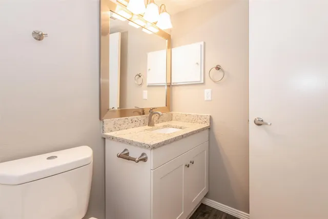 a bathroom with a sink vanity and toilet