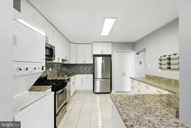 a kitchen with a refrigerator and a stove top oven