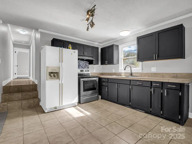 a kitchen with stainless steel appliances a refrigerator and a sink