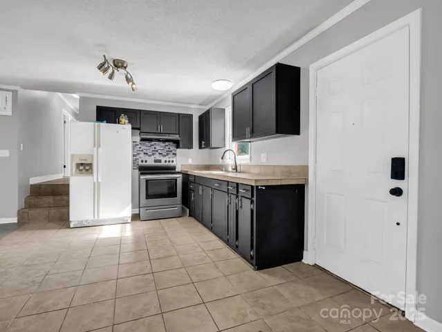a kitchen with stainless steel appliances a sink and a refrigerator