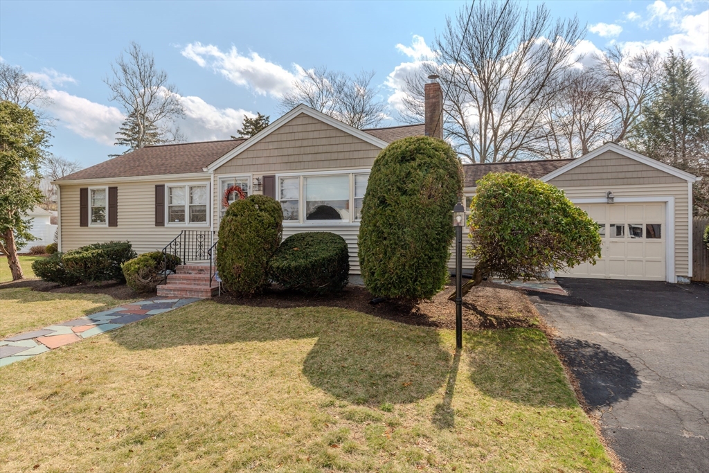 a view of a house with a yard and large tree