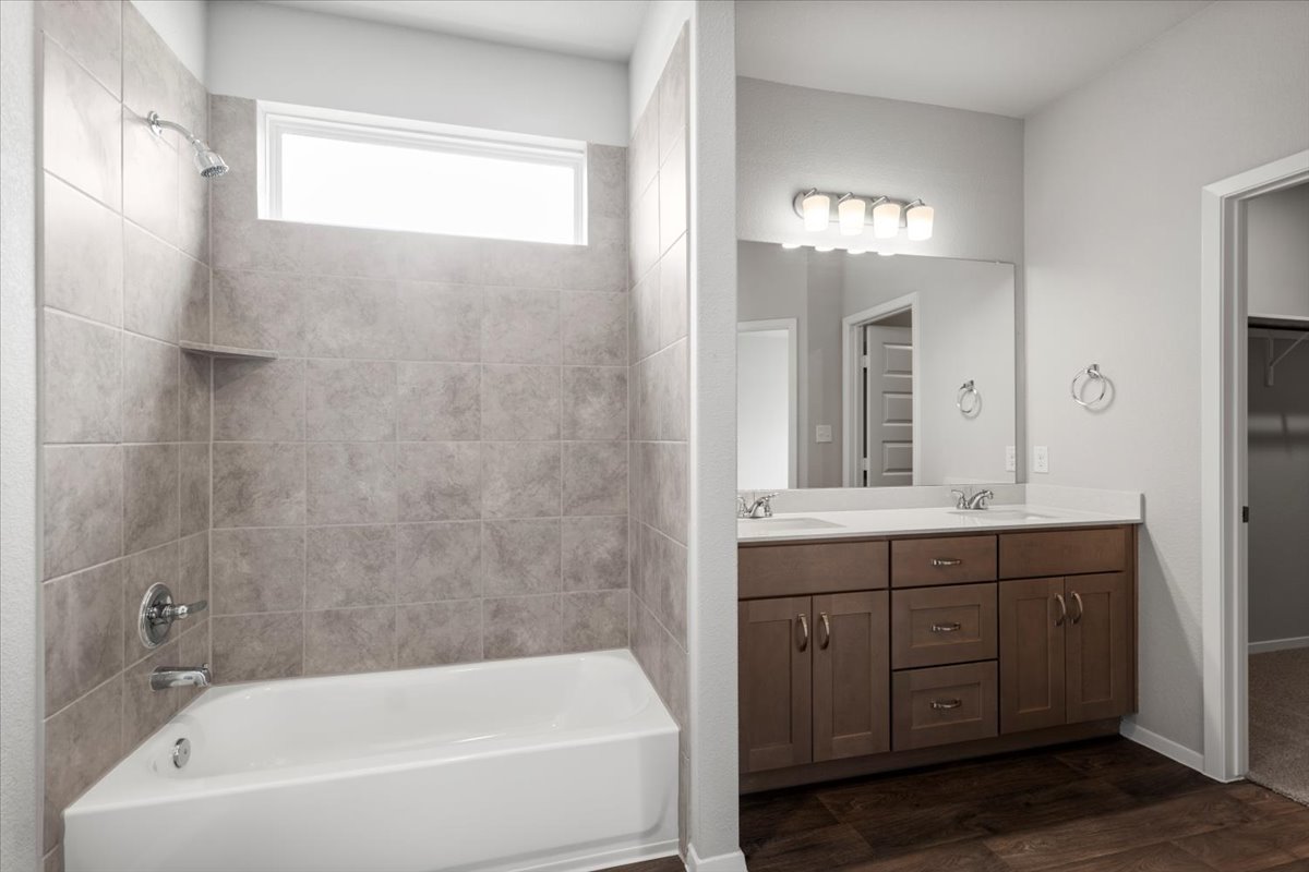 2603 Totley Road Manor, TX 78653 - Photo 20 of 37 Full bath featuring wood finished floors, double vanity, and shower / bathtub combination