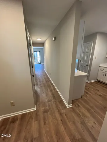 a view of a hallway with wooden floor and staircase