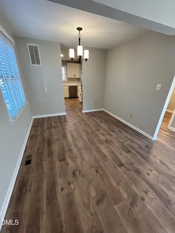 a view of empty room with wooden floor
