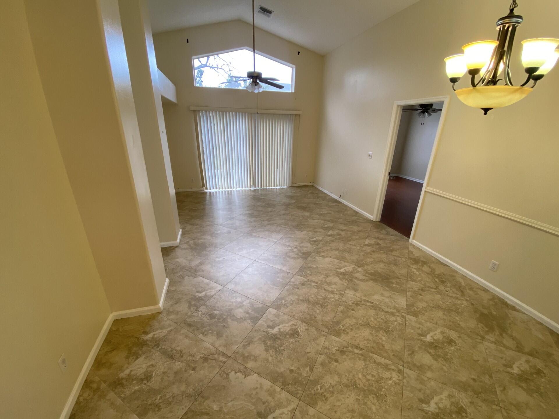 1051 Aviary Road Wellington, FL 33414 - Photo 4 of 10 en view of a big room with windows and chandelier fan