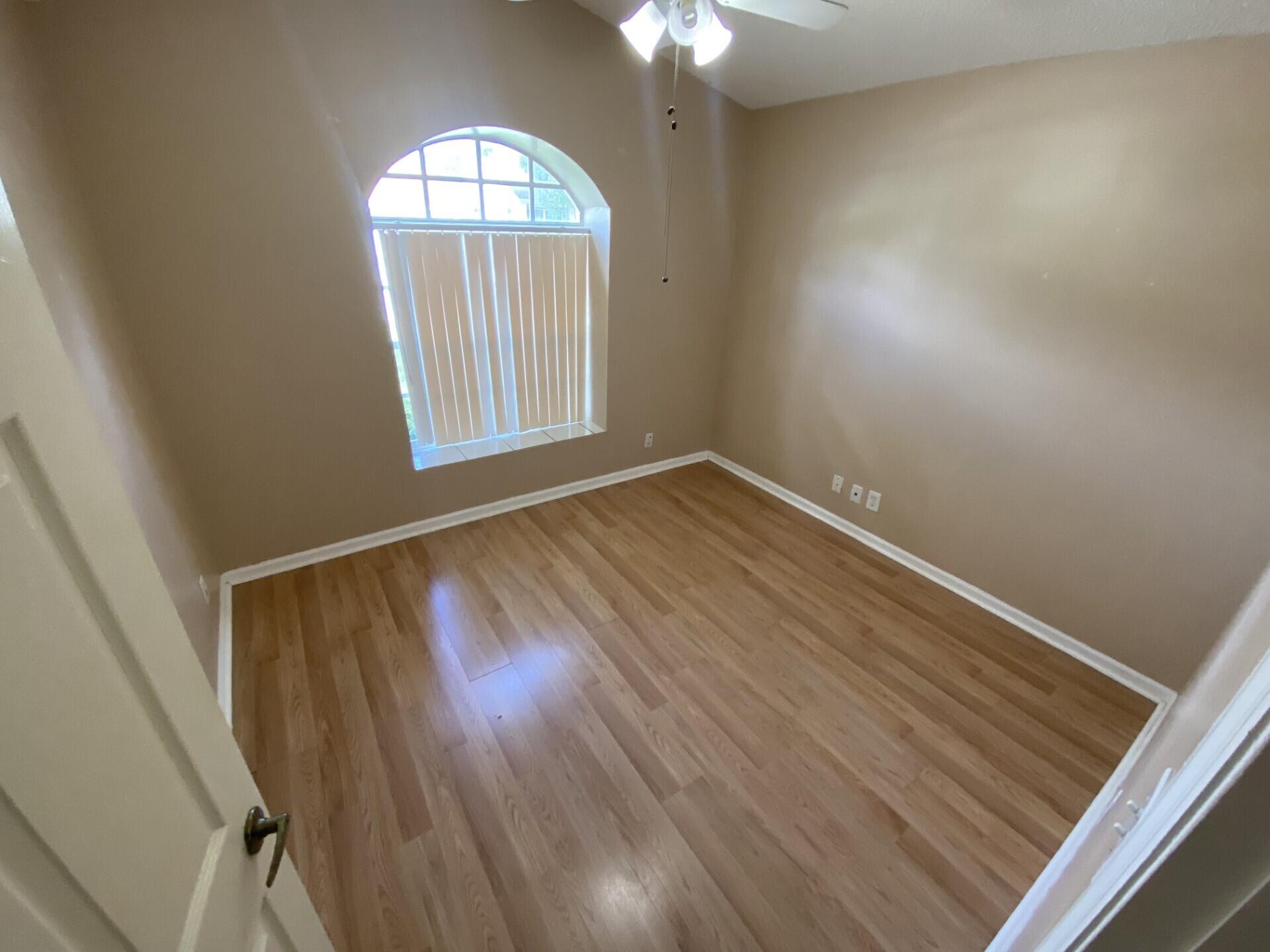 1051 Aviary Road Wellington, FL 33414 - Photo 7 of 10 an empty room with wooden floor fan and windows