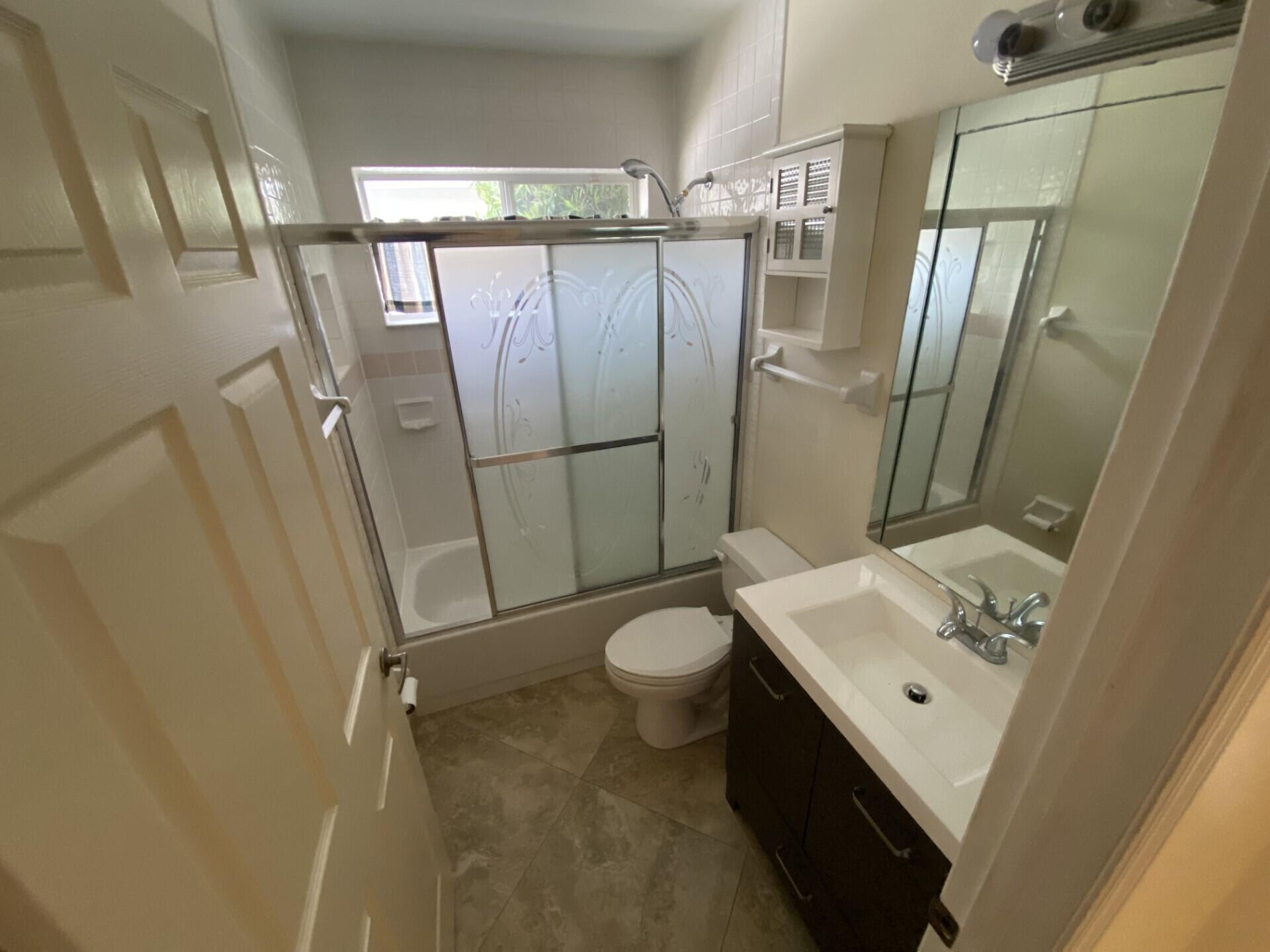 1051 Aviary Road Wellington, FL 33414 - Photo 8 of 10 a bathroom with double vanity sink toilet and shower